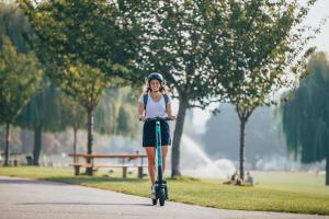 Frau auf E-Scooter im Park