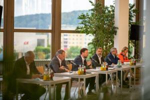 Sechs Männern und eine Frau an einem Tische