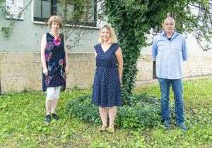 Drei Menschen – zwei Frauen und eine Mann –stehen auf eine Wiese und schauen in die Kamera 