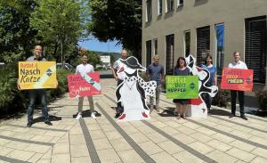 Eine Gruppe mit Menschen haben bunte Plakate in der Hand