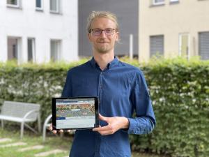 Ein Mann hält ein iPad in die Kamera 