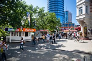 Blick in die Fußgängerzone Johannisstraße mit Fußgängern, Radfahrern und dem Jentower in Hintergrund.