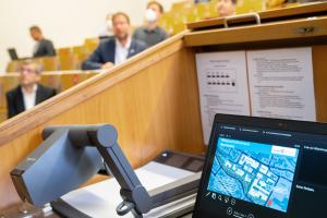 Blick auf Projektor, Bildschirm und Teilnehmende der Pressekonferenz