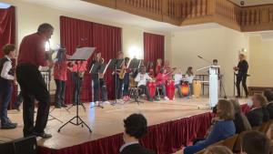 Viele musikspielende Menschen auf einer Bühne