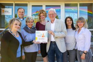 Viele Menschen halten ein Schild in die Kamera