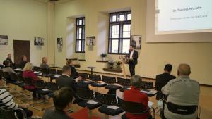 Ein Mann redet vor vielen Menschen