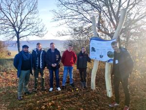 Menschen stehen in der freien Natur um eine Informationstafel