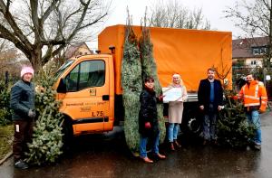 Fünf Menschen halten Weihnachtsbäume