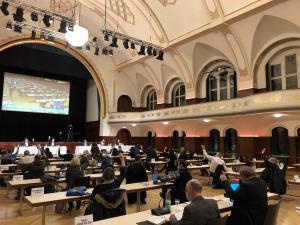 Ein großer Saal mit Menschen am Tisch