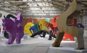 Mehrere große farbige Skulpturen stehen in einem großen hellen Raum.