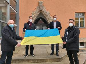 Vier Männer halten eine Fahne