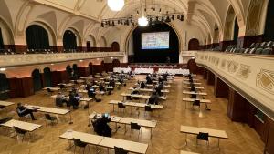 Ein großer Saal mit Menschen am Tisch