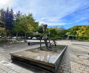 Eine Plattform mit Wasser auf der eine dünne, große Frauenfigur liegt.