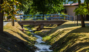 Ein Bach fließt unter einer Brücke entlang.