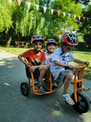 Drei Kinder auf einem Tretfahrzeug