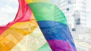 Blick auf die Innenstadt durch eine wehende Regenbogenfahne