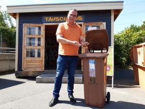 KSJ-Werkleiter Uwe Feige wirft Korken in einen Sammelbehälter. 