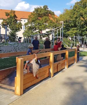 Erwachsene und Kinder an einer großen Wippe