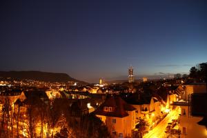 Blick auf den Jentower bei Nacht, rings um beleuchtete Häuser