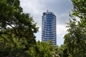 Ein großer Turm ragt zwischen Bäumen hervor.