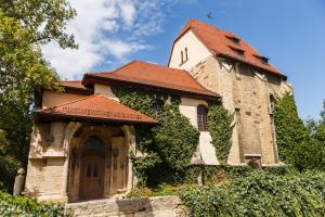 Mehrere alte steinerne Gebäude mit einer Kirche im Grünen