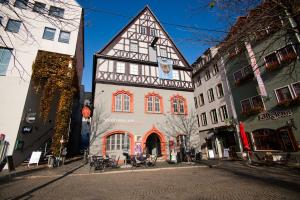 Ein altes graues Haus mit Fachwerk auf einem gepflasterten Platz