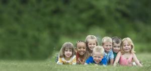 Eine Gruppe von Kindern liegt auf einer Wiese.