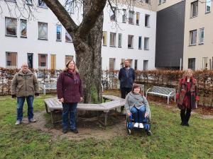 Auf dem Foto stehen im Freien mit Abstand nebeneinander 5 Personen: zwie Männer und drei Frauen
