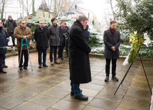 Menschen verharren vor einem Kranz