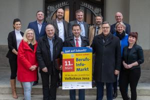 Eine Gruppe von Menschen hält ein Plakat in die Kamera