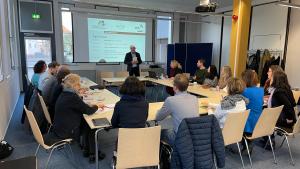 Ein Mann spricht zu einer Runde von Menschen