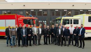 Eine Gruppe von Männern vor zwei Feuerwehrwagen