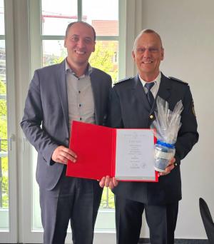 Bürgermeister Christian Gerlitz überreicht die Ernennungsurkunde an Branddirektor Peter Schörnig
