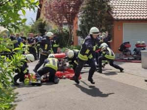 Feuerwehrmänner rennen mit Schläuchen in der Hand