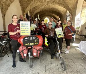 Menschen mit Fahrrädern schauen in die Kamera