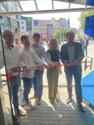 Menschen schneiden zur Eröffnung ein Band durch