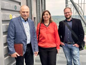 Eine Frau und zwei Männer schauen in die Kamera