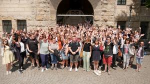 Viele Menschen winken in die Kamera