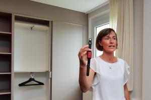 Stadtwerke-Projektleiterin Mandy Steinbrück zeigt den Notrufknopf, über welchen Patienten aus den Gesundheitsapartments Hilfe vom direkt benachbarten Universitätsklinikum anfordern können.