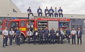 Feuerwehrleute vor Feuerwehrfahrzeug