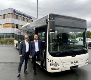 Zwei Männer stehen vor einem Bus.