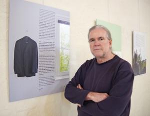 Künstler vor Ausstellungstafel