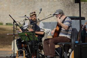 Zwei Männer mit Musikinstrumenten auf einer Bühne