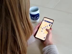 Eine Frau schaut sich am Smartphone die Wandelkarte Jena an.