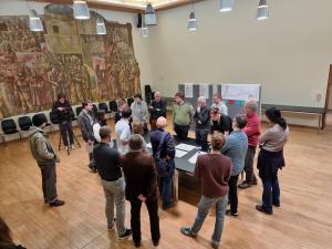 Mehrere Personen stehen um einen Tisch mit Plänen