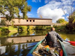 Zwei Personan fahren mit ein mit Müll belandenes Kanu beim SaalePUTZ bei der Kunitzer Hausbrücke über die Saale.