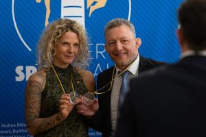 Zwei Menschen halten ihre Medaillen als Auszeichnung zum "Sportler des Jahres" hoch