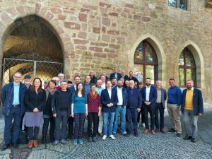Gruppe von Männern und Frauen stehen vor dem Historischen Rathaus für ein Gruppenfoto