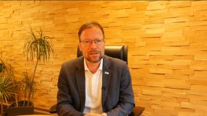 Oberbürgermeister Thomas Nitzsche sitzt auf einem Stuhl in seinem Büro und spricht.