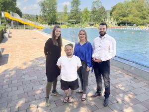 Vier Personen stehen vor einem Freibad